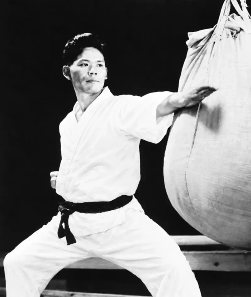 Master Yoshitaka Funakoshi striking the heavy sandbag with shuto in kiba-dachi